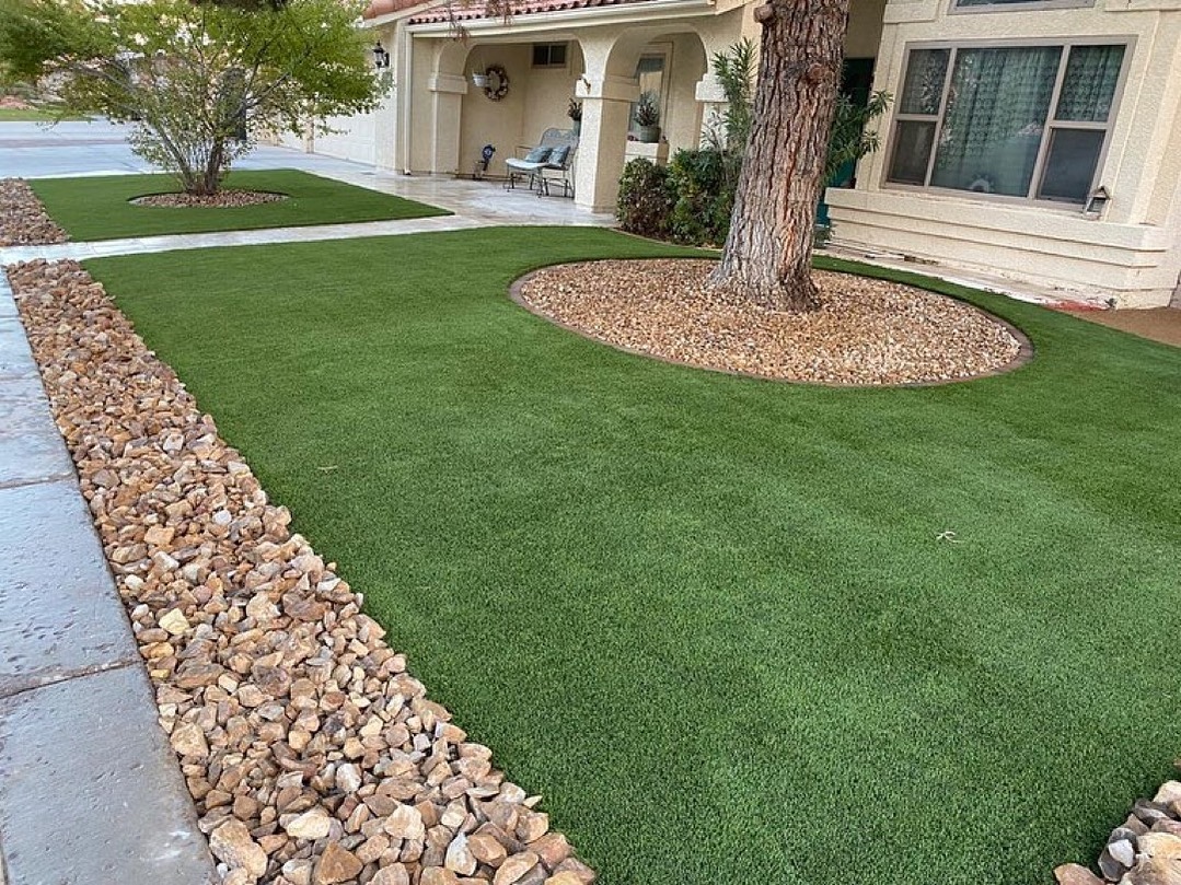 Landscaped front yard with artificial grass and decorative rocks